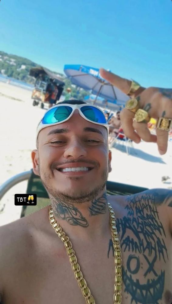 Lucas na praia, de óculos escuros